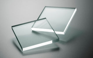 Square pieces of transparent acrylic sheeting on a gray background